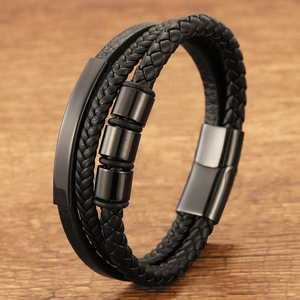 Men's multilayer black leather braided bracelet with magnetic buckle on wooden background