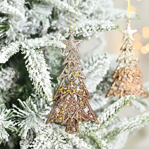 Champagne gold Christmas tree star ornament with glitter finish on snowy branch