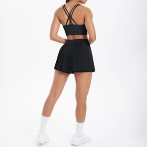 Détails de la brassière noire à dos croisé et de la jupe-short plissée de fitness