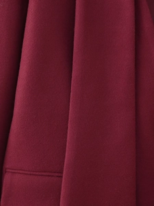 Macro shot of premium wine red wool fabric texture with elegant drape and fine fiber detail