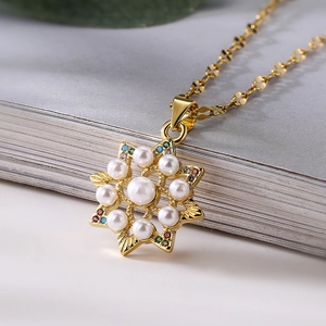 Collier doré avec pendentif étoile orné de perles et de gemmes colorées sur un livre