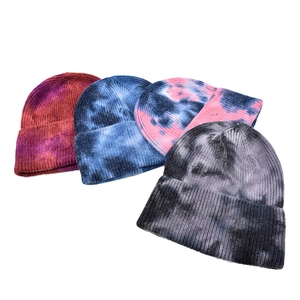Detail of four tie-dye knitted beanies with ribbed texture and rolled edge designs