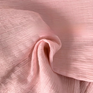 Detail shot of the pink textured ripple fabric showing soft pleated material and drape