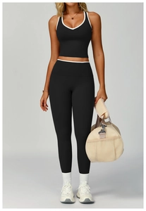 Dettaglio del set yoga nero con bordi bianchi a contrasto su reggiseno e leggings