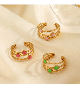 Detailed view of three layered gold-plated rings with pink, red, and green enamel beads