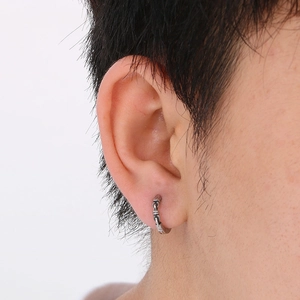 Close-up of retro silver hoop earring with chain texture shown on ear
