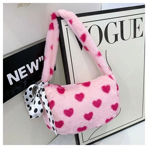 Detail of pink plush handbag with heart patterns and polka dot silk scarf handle decor