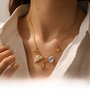 Detail of ocean-themed necklace with starfish, shells and heart pendant on white shirt