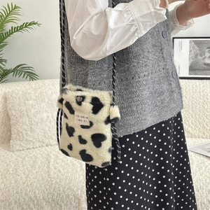 Detail shot of plush heart pattern mini crossbody bag with a rope strap and woven label
