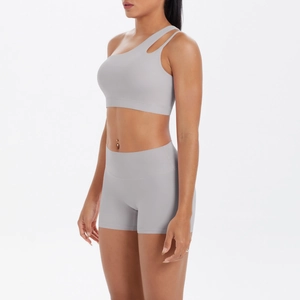 Detail of light grey one-shoulder yoga set showing elastic fabric and side cut-out design