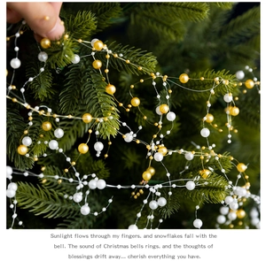 Close-up of white and gold crystal bead garland wrapped on green Christmas tree branches