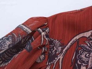 Close-up of reddish-brown vintage floral print fabric with pleated texture details