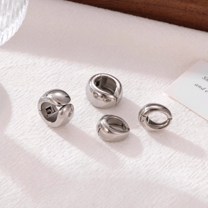 Minimalist silver mirror polished metal hoop earrings in different sizes on white fabric