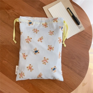Close-up of blue striped drawstring bag with bear prints and a simple wish textile label