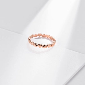 Minimalist rose gold ring featuring a continuous heart pattern design on white background