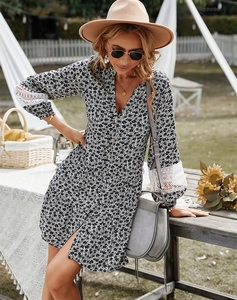 Detail of elegant black and white floral shirt dress with delicate white lace cuffs