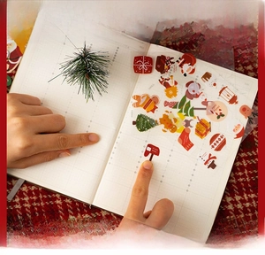 Close-up of Christmas PET stickers showing Santa and reindeer designs on a notebook