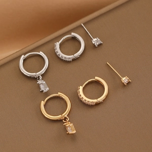 Detailed close-up of gold and silver earring set featuring zircon studs and diamond hoops