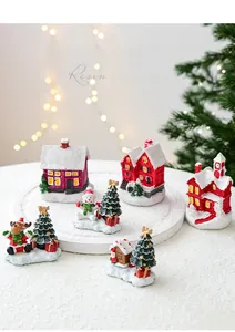Detailed close-up of resin Christmas ornaments featuring a mini house and snowman