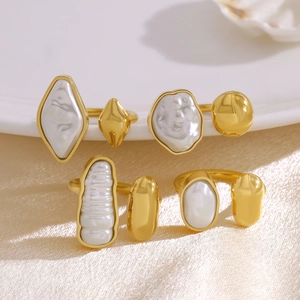 Detailed view of irregular baroque pearls and white agate set in gold plated open rings