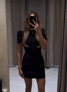 Mirror selfie showing fit of a black puff sleeve bodycon mini dress on a model