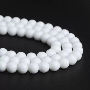 Macro shot of smooth round white sunstone beads for DIY jewelry making on black background