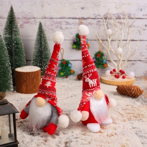 Pair of festive Christmas gnomes in knitted hats with reindeer patterns on snow base