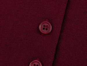 Gros plan sur la maille bordeaux et les boutons en résine assortis à quatre trous du polo