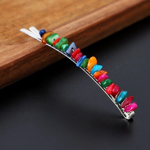 Detailed close-up of a silver hair pin featuring vibrant, natural colorful crystal stones