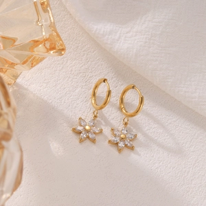 Exquisite golden sunflower drop earrings with sparkling zircons on white textured fabric