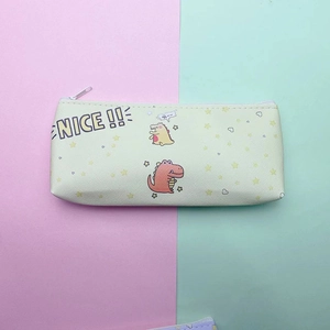 Detailed close-up of yellow dinosaur pencil case with NICE lettering and white zipper