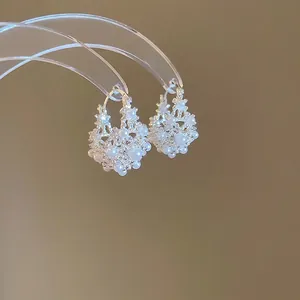 Elegant U-shaped hoop earrings with woven white pearls and silver beaded metal frame