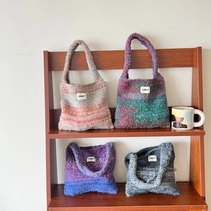 Knitted gradient shoulder bags in mixed colors on wooden shelves for daily style