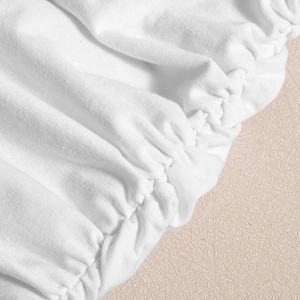 Détail du tissu tricoté blanc montrant des bords froncés élastiques et une texture douce