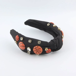 Détail d'un serre-tête noué noir avec des ornements de basket-ball et des strass
