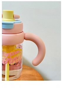 Detail van de brede ergonomische handgreep op de plastic drinkfles met een rietje