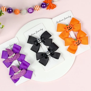 Detail of Halloween hair clips with bows featuring bat, pumpkin, and wizard hat designs