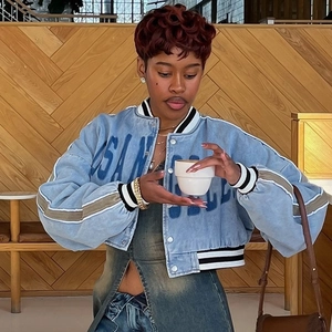 Women's cropped light blue denim baseball jacket with striped ribbing and front print