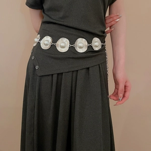 Detail of silver waist chain with round pearl-inlaid charms and elegant tassels