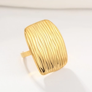 Macro detail of golden titanium steel ring showing unique textured wavy surface pattern