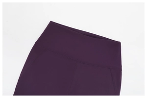 Macro shot of high-waisted wide elastic waistband on dark purple yoga flare pants