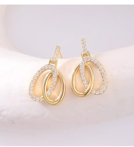 Macro shot of double interlocking oval earrings with gold finish and white zircon stones