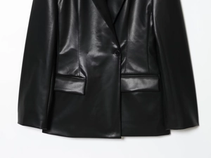 Close-up of slim-fit faux leather blazer showing smooth texture and button detail