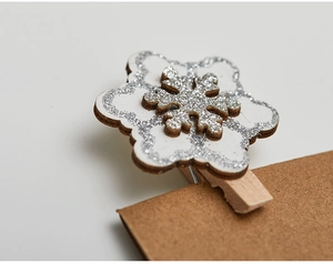 Detail of wooden Christmas snowflake clip with silver glitter and natural wood texture