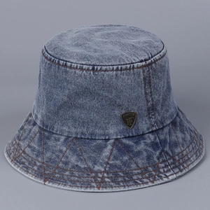 Detail of washed blue denim bucket hat with brown stitching and metallic shield logo