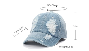 Detailed view of distressed denim baseball cap showing 85g weight and frayed hole texture