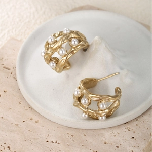 Artistic C-shape matte gold earrings with hollow flow texture and white pearls