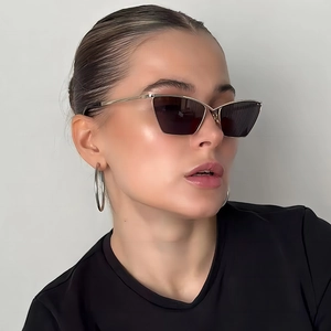 Detail view of stylish geometric cat-eye sunglasses with gold metal temples and dark lenses