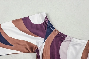 Macro shot of swirl print fabric on shoulder seam with precise white stitching details