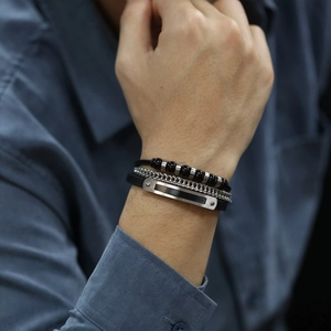 Détail d'un bracelet multicouche pour homme avec perles noires et plaque en argent